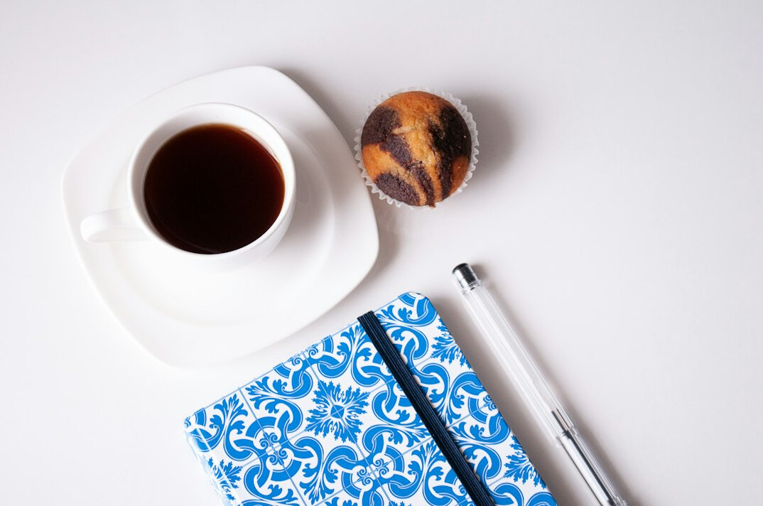 Notebook with a pen and a cup of coffee